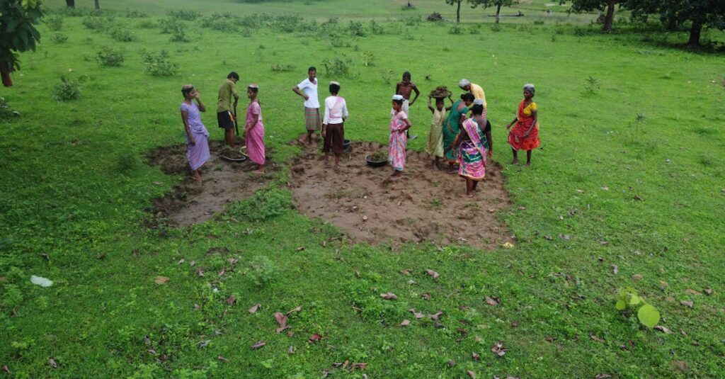 Aerial view of a group farming scene in lush green fields of India.